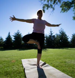 Woman doing yoga in the grass.